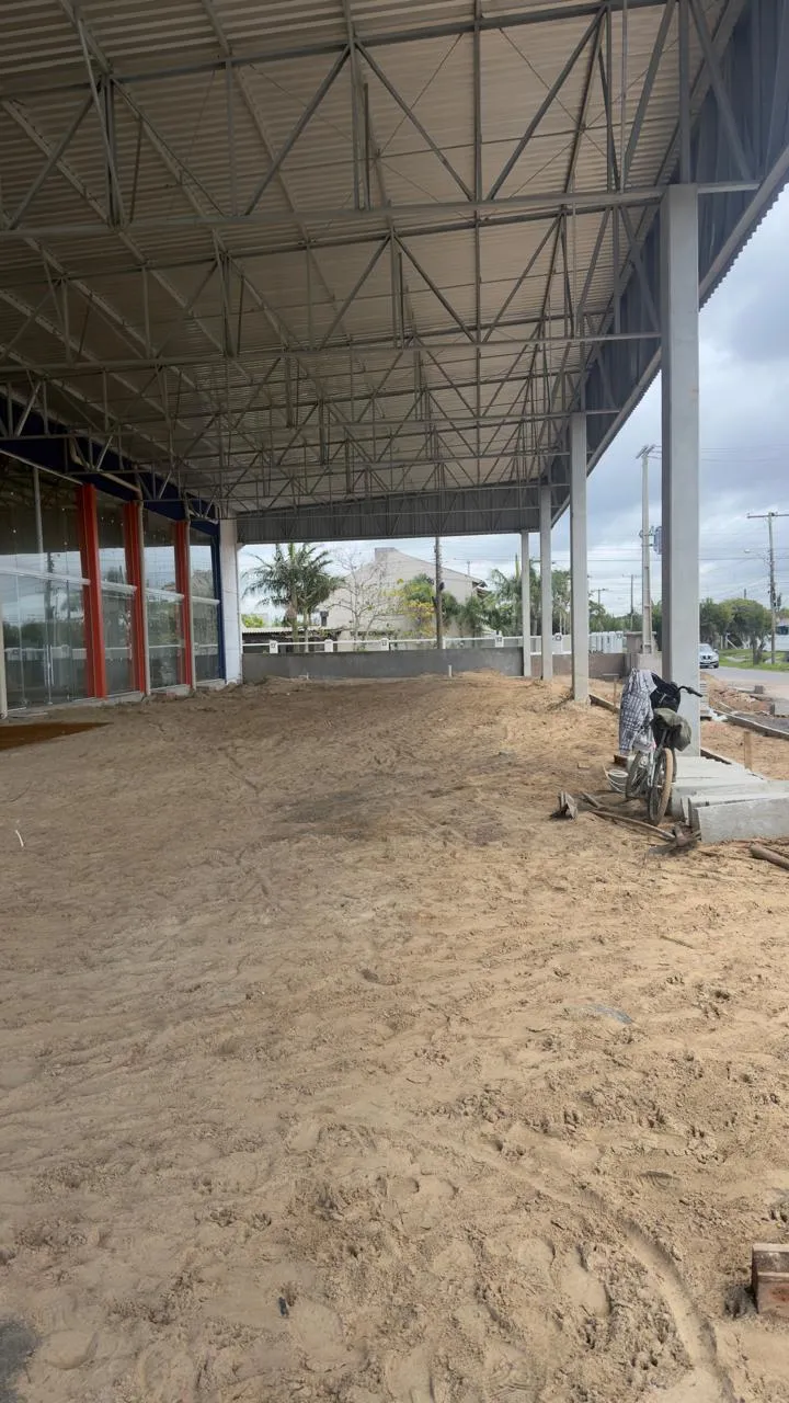 Área coberta por estrutura metálica com solo preparado, ainda sem piso